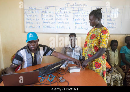 Sur les frontières du Soudan du Sud et en Ouganda. La prise des empreintes digitales, travailleur du HCR avant que le réfugié est admis dans l'Ouganda. Banque D'Images