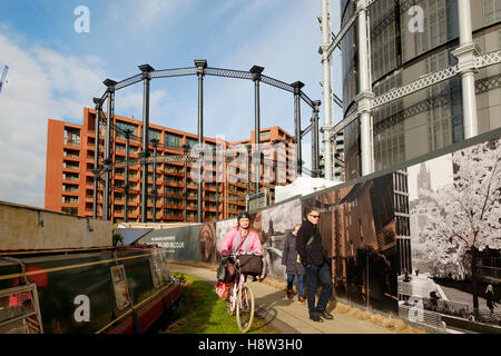 Les gens sur le chemin de halage du Regents Canal at St Pancras passant le Gasholder développement du parc. Kings Cross, Londres. Banque D'Images