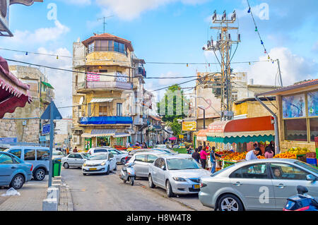 L'étroite rue du Marché Arabe à Wadi Nisnas quartier est plein de fruits et légumes et des voitures en stationnement Banque D'Images