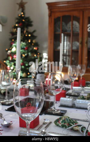 Le tableau mis en place avec des craquelins et des chandeliers prêt pour le déjeuner de Noël avec un arbre dans le coin Banque D'Images