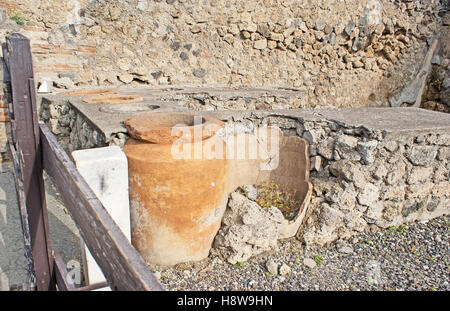 Les anciens pots d'huile d'olive construite en mur de l'immeuble en ruine, Pompéi, Italie. Banque D'Images