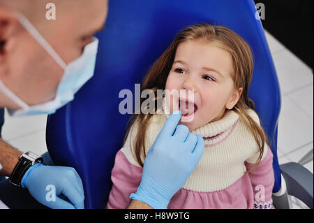 Petit mignon petite fille à la réception chez le dentiste Banque D'Images