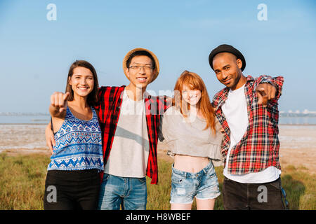 Groupe multiethnique de smiling young people standing together et pointant sur vous Banque D'Images