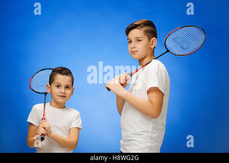 Les deux garçons avec des raquettes de badminton en plein air Banque D'Images