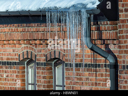 Les aiguilles de glace avec de l'eau avec la construction de murs en brique. Banque D'Images