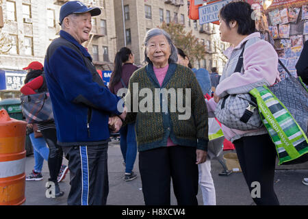 Un couple de personnes âgées du shopping sur la rue Main, au centre-ville de Flushing, Queens, New York Banque D'Images