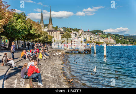 Les touristes se détendre au bord du lac Lucerne Schweizerhofquai en été, Lucerne, Suisse Banque D'Images