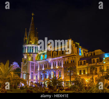 La célèbre tour astronomique dans des lumières du soir est vu à travers la verdure de jardin à côté de l'Europe Square, Batumi, Géorgie. Banque D'Images