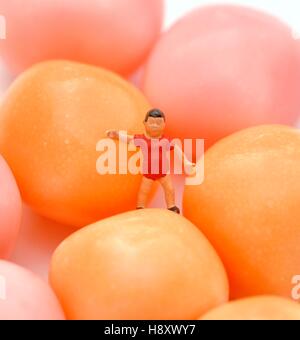 Figurine miniature jeune garçon debout à côté de la sucrerie ou bonbon Banque D'Images