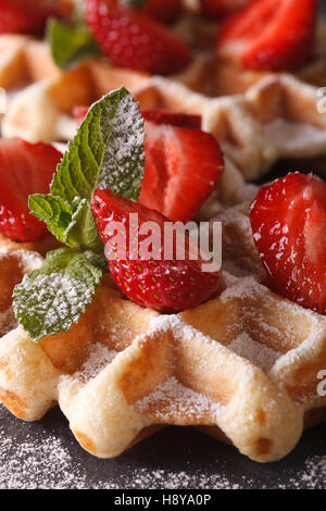 Gaufres Belges avec fraises et menthe macro sur le tableau en ardoise verticale. Banque D'Images