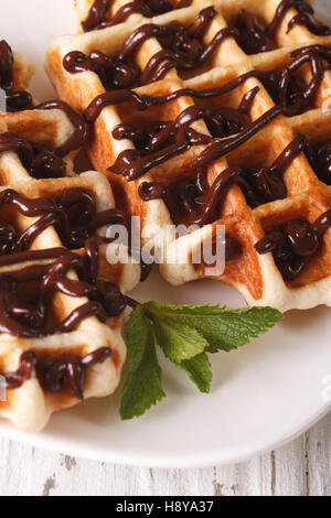 Garni de gaufres belges et de menthe chocolat macro sur une assiette. La verticale Banque D'Images