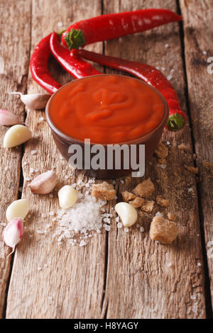 Sriracha sauce chili rouge avec des ingrédients sur la table verticale. Banque D'Images