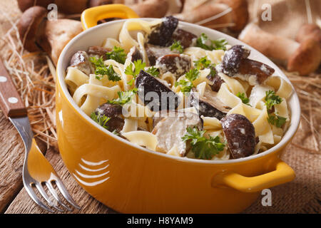 Pâtes fettuccine aux cèpes et sauce crème close-up dans un pot jaune horizontale. Banque D'Images