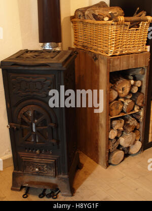 Poêle à bois avec rustic log store Banque D'Images