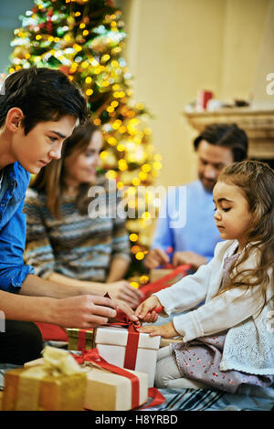 Petite fille aider son frère nœud de cravate sur cadeau de noël-box Banque D'Images