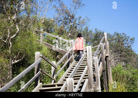 Mère et fille marchent jusqu'à North Narrabeen promontoire sur les plages du nord de Sydney, nouvelle galles du sud, Australie, escalier en bois de bois Banque D'Images