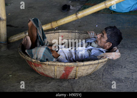 Dhaka, Bangladesh. 17 novembre 2016. Un travailleur du Bangladesh marché cuisine dort sur le panier à Karwan Bazar marché cuisine à Dhaka, au Bangladesh. Karwan Bazar est l'un des plus grands marchés de gros de la ville de Dhaka en cuisine. C'est aussi l'un des plus grands marchés de cuisine en Asie du Sud. En 2002, le marché avait 1255 magasins, dont 55 étaient la propriété de la société de la ville de Dhaka. En 2002, le marché de gros a un revenu quotidien de 50 millions de taka bangladais. © Mamunur Rashid/Alamy Live News Banque D'Images