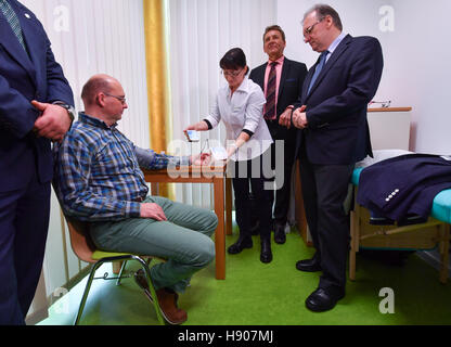 Le Premier Ministre de l'état de Saxe-anhalt Reiner Haseloff et Peter Loebus de AOK regardez comme Simone Taschner et Jan Hofflann (R-L) Démontrer la transmission d'un smartphone par lecture de la pression artérielle à un médecin à Halle/Saale, Allemagne, 17 novembre 2016. La manifestation a lieu dans le cadre d'une conférence de presse sur le projet pilote intitulé "Vivre avec la télémédecine à la Halle 4.0." L'objectif est que les personnes à mobilité réduite sera en mesure d'envoyer régulièrement de l'information médicale - comme les mesures de pression - cc directement à leur médecin à l'aide d'un ordinateur. La Saxe-Anhalt compte jouer un Banque D'Images