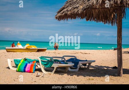 Chaises de plage à l'ombre d'une paillote Banque D'Images