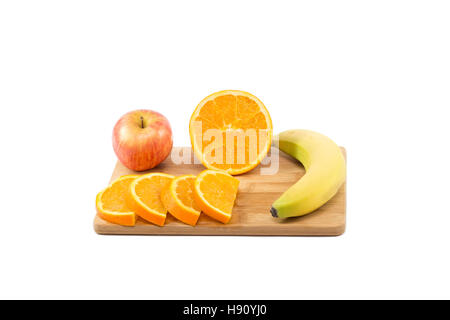 La moitié des fruits et des tranches d'orange, pomme et banane sur planche de bois isolé sur fond blanc Banque D'Images