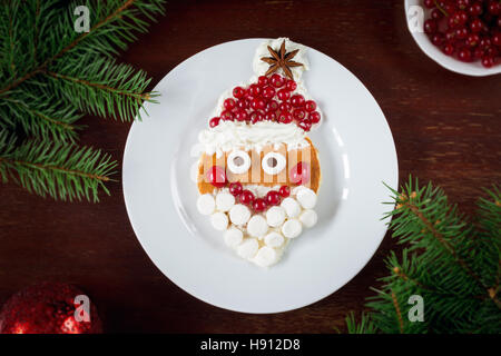 Santa Claus pancake ! Petit-déjeuner d'art créative pour les enfants à Noël ou Nouvel An. Vue de dessus, plaque blanche backgrounf Banque D'Images