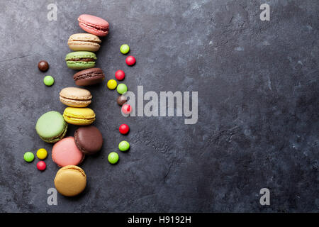 Colorful macarons et bonbons sur table en pierre. Macarons sucrés. Vue de dessus avec l'exemplaire de l'espace pour votre texta Banque D'Images