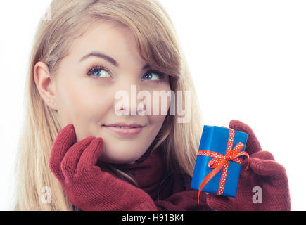 Vintage photo, Smiling woman in woolen gloves holding wrapped cadeau pour Noël, la Saint-Valentin, un anniversaire ou autre fête, fond blanc Banque D'Images