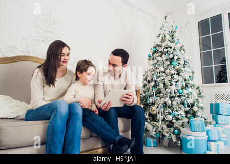 Noël, x-mas, l'hiver, le bonheur, les hommes et la technologie concept - smiling family with tablet pc Banque D'Images