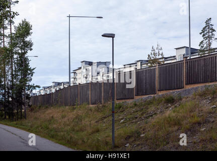 Mur de protection contre le bruit, une barrière le long de la route européenne. Règlement de banlieue moderne à l'arrière-plan. Giliano residence ce côté. Banque D'Images