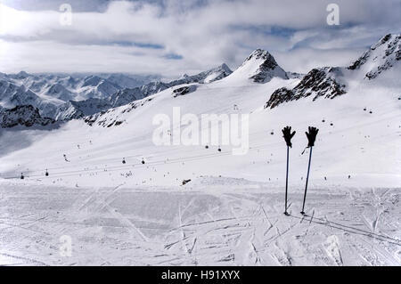 Bâtons de ski avec des gants de ski télécabine, téléphérique, téléski, et les skieurs sur la pente sur Tiefenbach glacier dans les Alpes, Sölden, Autriche Banque D'Images