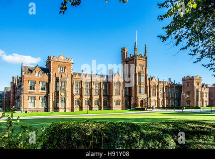 La Queen's University de Belfast avec une pelouse, des branches d'arbre et une couverture dans la lumière au coucher du soleil Banque D'Images