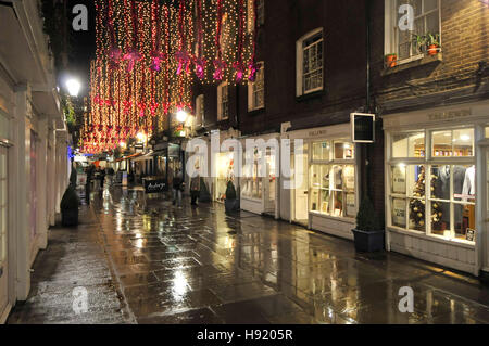 Décorations de Noël lumières London West End shopping manger hors zone avec peu de boutiques haut de gamme St Christophers place juste à côté d'Oxford Street nuit pluvieuse Banque D'Images