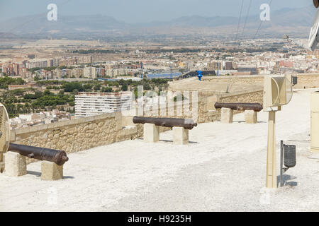 Ligne de canons antiques dans le rempart du château de Santa Barbara avec la ville d'Alicante, l'Espagne dans le contexte Banque D'Images