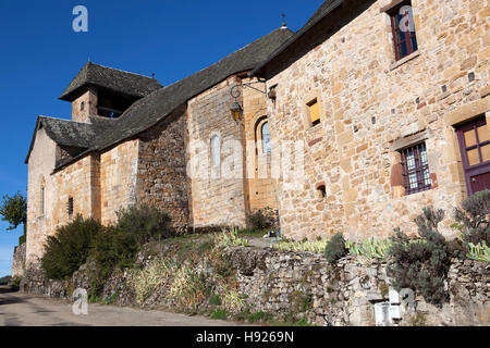 Faite de grès rose, l'église et une vieille maison à la rue principale du village de Rodelle (Aveyron - France). Banque D'Images
