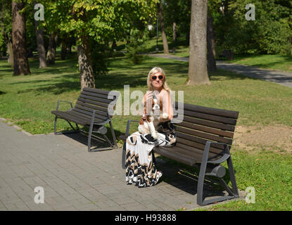 Femme et son Chien - Cavalier King Charles Spaniel, Blenhein, reposant sur un banc de parc en ville de Nis en Serbie Banque D'Images