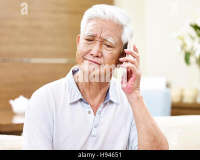 Senior asian man using mobile phone, semble être malheureux, triste ou en colère Banque D'Images