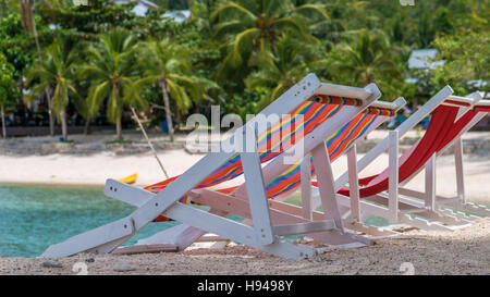 Appel chaises de plage sur le sable. Palmiers et l'océan en arrière-plan. Haad Salat. Koh Pangang, Thaïlande Banque D'Images