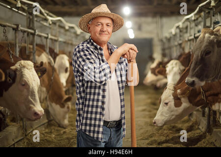 Agriculteur mature posant dans une étable Banque D'Images