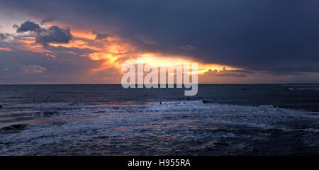 Lyme Regis Dorset, UK. 18 Nov, 2016. Un internaute bénéficie du magnifique coucher de soleil au large de Lyme Regis dans le Dorset ce soir Crédit : Simon Dack/Alamy Live News Banque D'Images