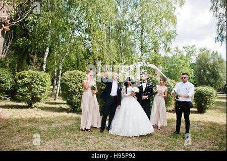 Couple de mariage élégant, groomsman et demoiselles avec champagne explosion. Banque D'Images