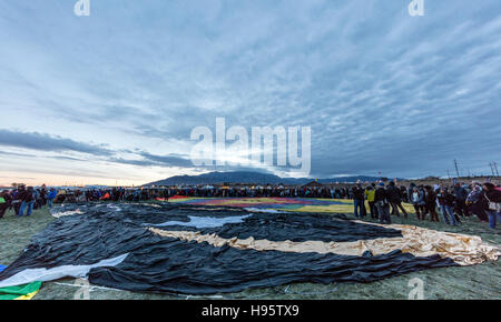 Usines de foule en attente d'une inflation de hot air balloon en vertu de l'aube du ciel menaçant, l'Albuquerque International Balloon Fiesta Banque D'Images