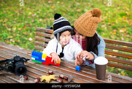 Mère avec son enfant jouer dans le parc et jouent avec des blocs Banque D'Images