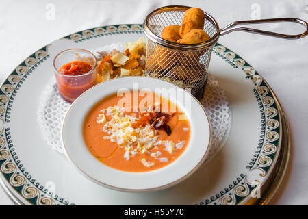 Table avec salmorejo avec du jambon et des œufs, hash, et sauce tomate Banque D'Images