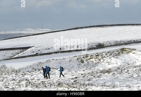 Les marcheurs font leur chemin à travers la neige sur Mam Tor dans le Derbyshire après l'hiver a apporté au sol dans la neige à travers le Peak District. Banque D'Images