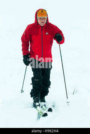 Un homme sur skis de fond près du col Buttertubs dans le Yorkshire Dales National Park après l'hiver a apporté au sol dans la neige dans le nord de l'Angleterre. Banque D'Images