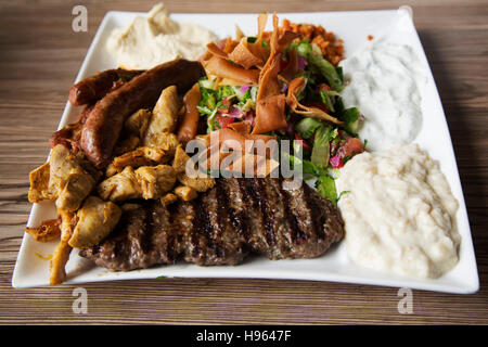 Un style d'Afrique du Nord cuisine servie dans la Markthal à Rotterdam, aux Pays-Bas. Le plateau dispose d'une grillade de viande, une salade et les trempettes. Banque D'Images