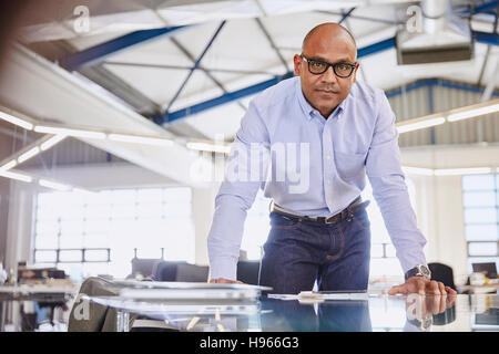 Portrait serious businessman leaning on conference room table Banque D'Images