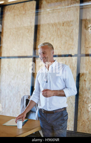 Smiling businessman with coffee dans la salle de conférence Banque D'Images