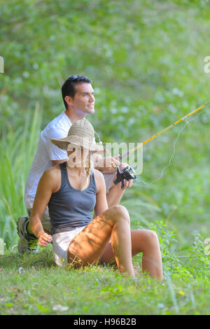 Jeune couple de la pêche sur les rives de l'étang Banque D'Images