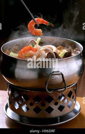 Fruits de mer chinois traditionnels sex pot avec une crevette qui s'est tenue dans une paire de baguettes Banque D'Images